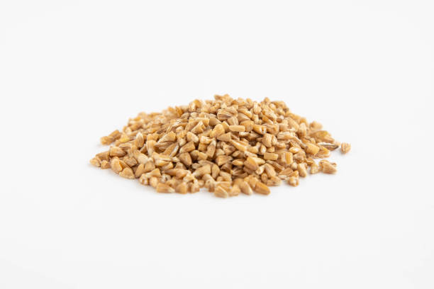 istock Handful of crushed whole wheat grain on a white background 1395177354