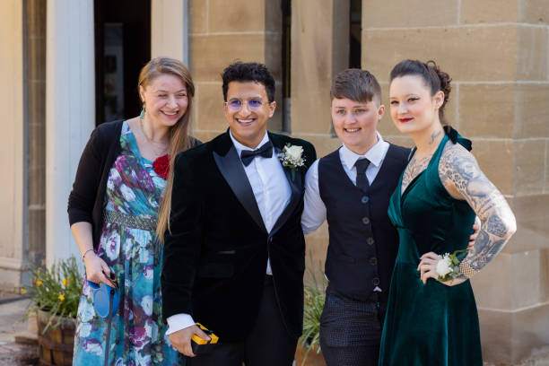A mid-length portrait view of a groom stood with some of his wedding guests at a public registry office in Durham in the North East of England