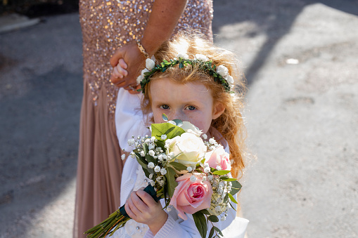 A close up high angle view of a young flower girl attending a wedding in County Durham in the North East of England,