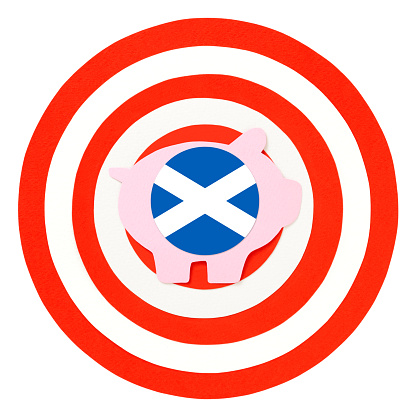 Paper illustration of piggy bank with Scottish flag over bull's eye