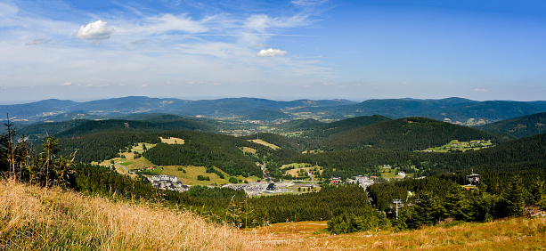 Mountain landscape, mountain range in the Sudetes, view from the vantage point on the mountain hiking trail at the top of the Czarna Gora mountain, sunny summer day.