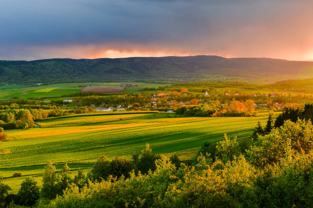 istock A storm front with heavy rainfall passes over the mountains and the valley, the sun's rays illuminate the landscape. 1395183403