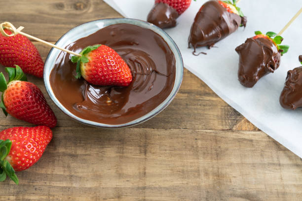 istock Strawberries with chocolate. Strawberries dipping process in chocolate. Copy space. 1395183532
