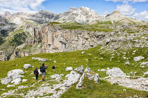 Adventures on the Dolomites: senior grandfather with family mountain hiking