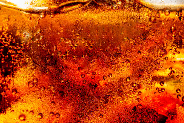 istock macro cola texture,cola with ice food background, cola close-up, design element. beer macro bubbles, ice, bubble, background, ice cubes, abstract backgrounds 1395185494