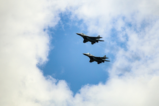 Two Fıghter Jet fighter jets flying in formation over the clouds.