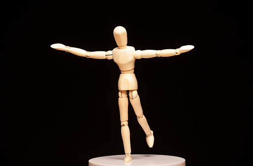 image of wooden figure balance dark background studio