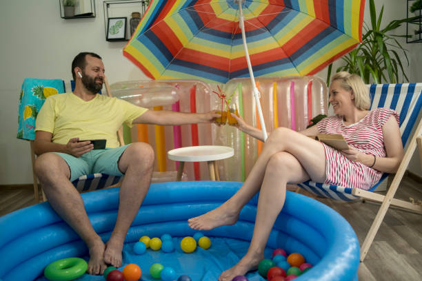istock Happy couple who cannot go on holiday has fun at home 1395190421