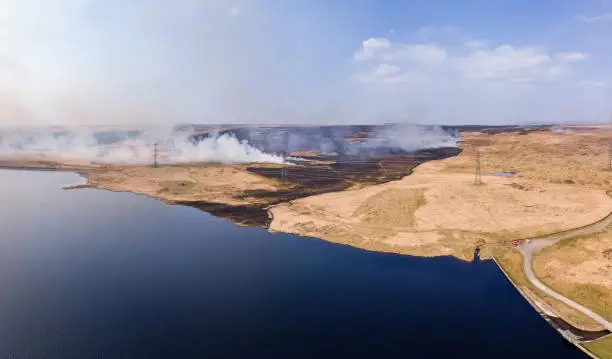 Aerial panoramic view of a large grassfire on moorland in Wales, UK