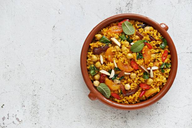 Vegan Moroccan Bulgur with Chick Peas, spinach, dried apricots and date fruit. Traditional African Tajine dish. Vegan Moroccan Bulgur with Chick Peas, spinach, dried apricots and date fruit. Traditional African Tajine dish. Flat layot bulgur wheat stock pictures, royalty-free photos & images