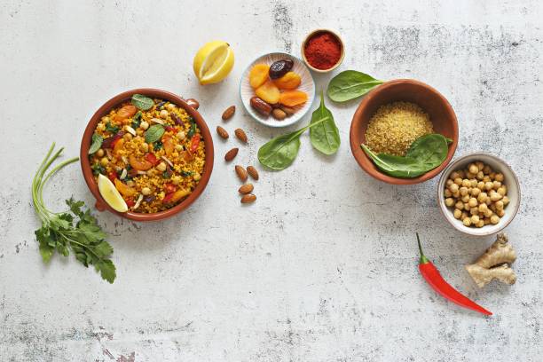 Vegan Moroccan Bulgur with Chick Peas, spinach, dried apricots and date fruit. Traditional African Tajine dish. Flat layot