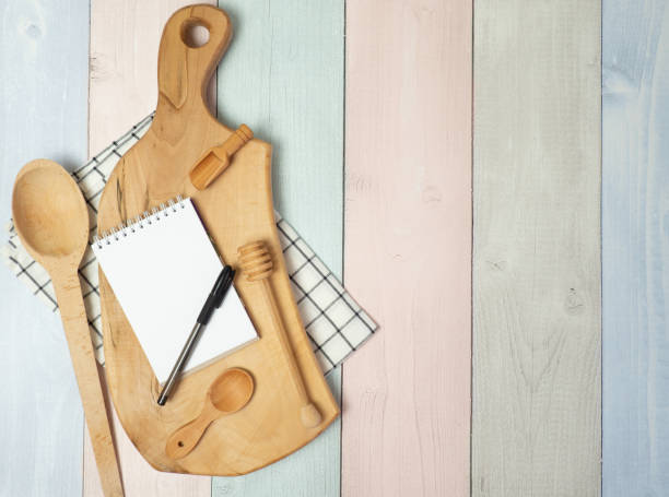 istock Notepad on cutting board with wooden kitchen utensils on the table, food recipes .copy space 1395193576