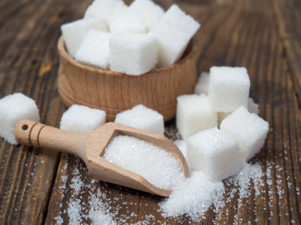 istock Stack of sugar cubes and granulated sugar in a wooden scoop 1395193593