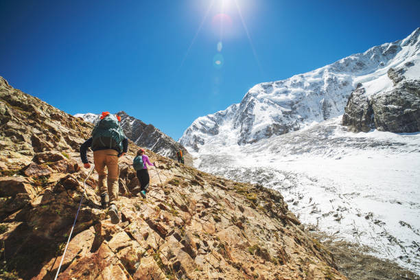istock Group of people climbing in mountains during summer vacation 1395194561