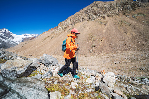One young woman trekking in mountains with glacier