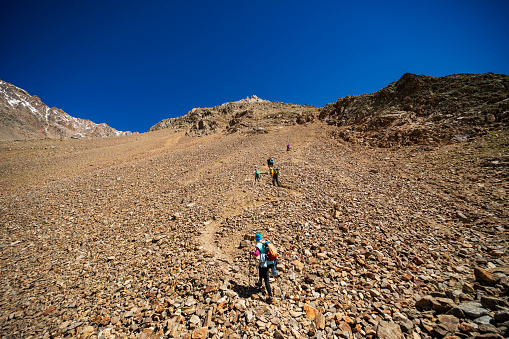 Group of tourists trekking in mountains during summer vacation