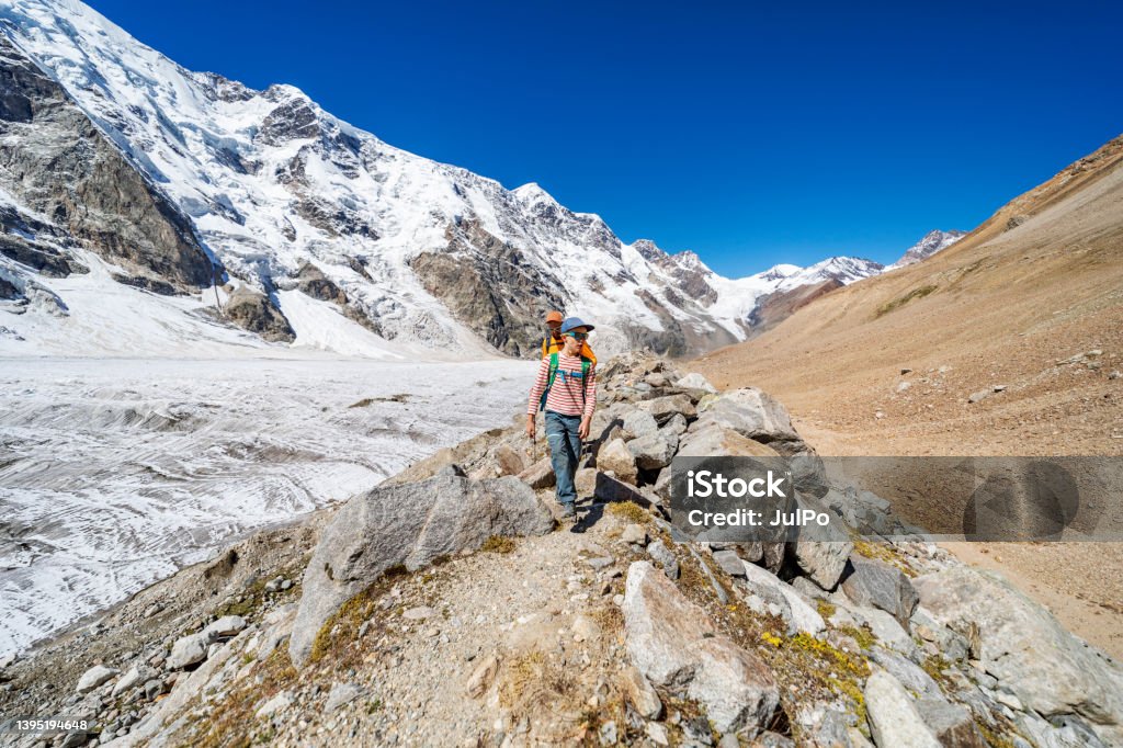 Father with son trekking in mountains during summer vacation Mount Elbrus Stock Photo