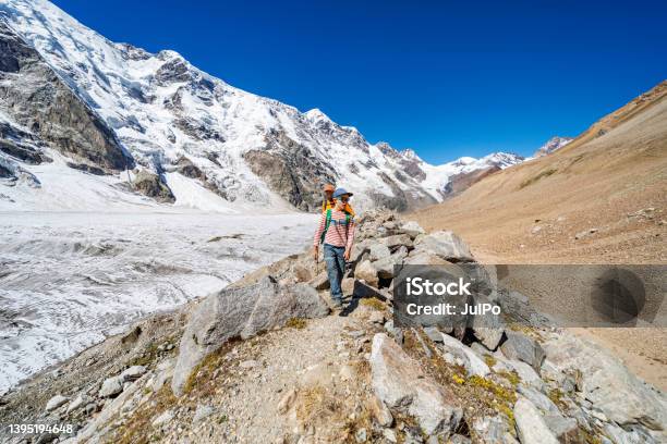 Father With Son Trekking In Mountains During Summer Vacation Stock Photo - Download Image Now