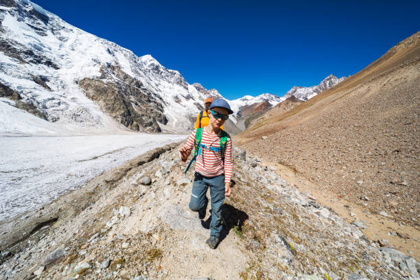 istock Father with son trekking in mountains during summer vacation 1395194650