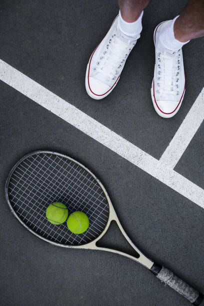 balle de raquette de tennis et jambes d’athlète sur la vue du haut du court - tournoi de tennis photos et images de collection