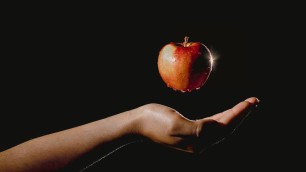 istock Hand holding an apple suspended in the air 1395194996