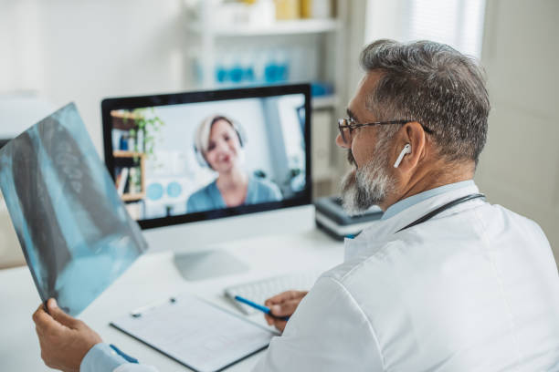 Doctor meeting remotely with his patient Doctor talking while explaining medical treatment to patient through a video call  in the consultation. He is analyzing x ray image of lungs. human cardiopulmonary system audio stock pictures, royalty-free photos & images