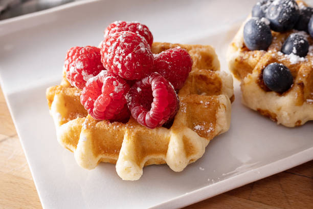 istock Homemade waffle with fresh raspberries on a white plate. 1395197919