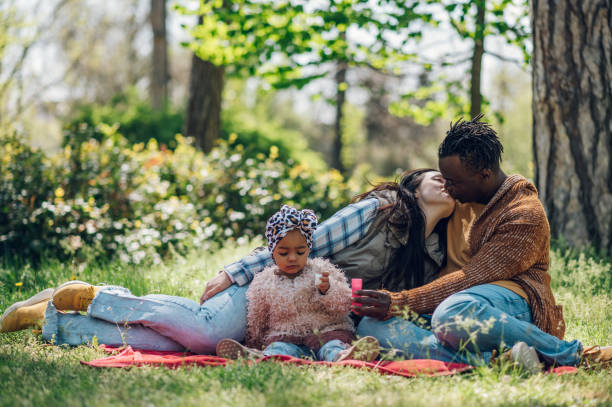 istock Diverse family blowing soap bubbles in park 1395201322