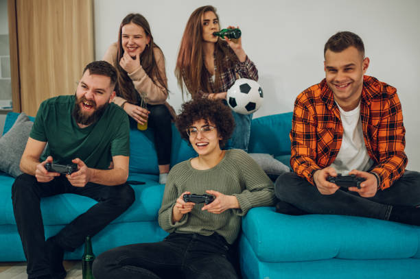 group of friends playing video games at home - gamer watching tv adult couple imagens e fotografias de stock