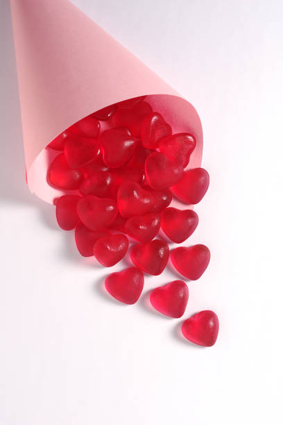 Heart shaped jelly candies in a paper bag on a white background
