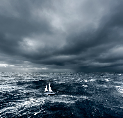 Sailing boat in rough ocean waves