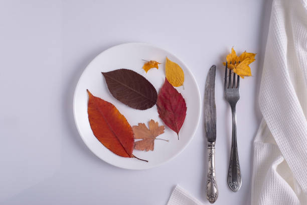 istock creative autumn concept canteen table setting autumn leaves on a plate on a white background 1395211050