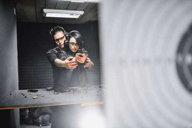 Firearms Instructor Teaching Female Shooter About Hand Stability On Gun Range