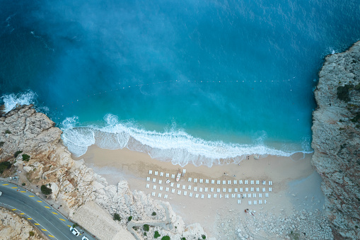 Top-down aerial view of a white sandy beach on the shores of a beautiful turquoise sea