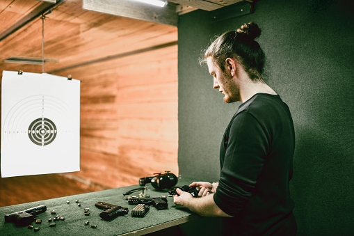 Male Shooter Deciding To Test Revolver Against Pistols On Range