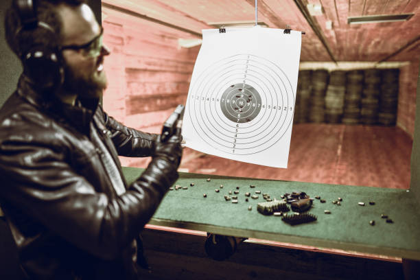 istock Male Shooter Checking His Groups With Different Firearms On Range 1395214706
