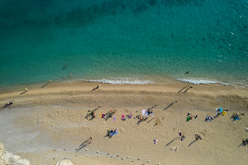 Top-down aerial view of a white sandy beach on the shores of a beautiful turquoise sea