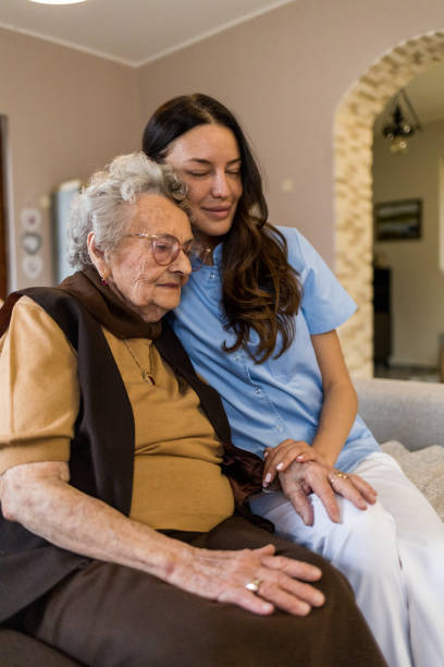 istock District nurse hugging her senior patient during home visit 1395215174