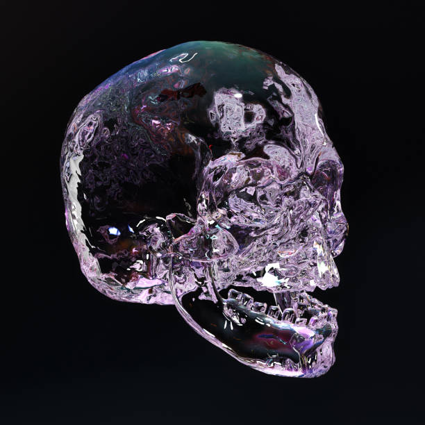istock A delicate crystal skull illuminated in seven colors on a dark background. 1395218409