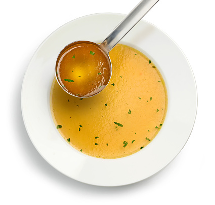 plate of fresh chicken broth on white background, top view