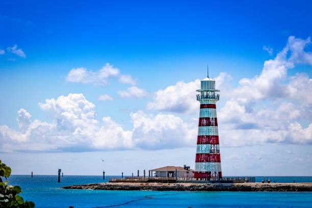 istock Stereotypical lighthouse on a cape of a tropical island 1395220456