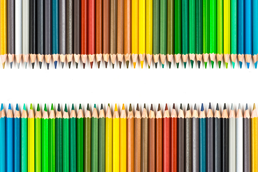 Studio shot of different coloured pencils against a green background