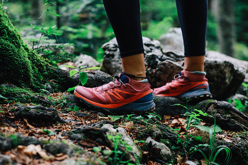 Close up image on woman’s hiking footwear in the forest.