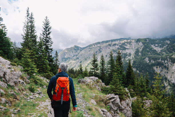 Mid aged man spending a nice day hiking in the nature. He is going across the mountain range of Dinaric Alps in the Southeastern Europe.