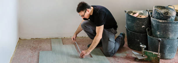 istock Bricklayer measuring tiles to install a floor 1395229712