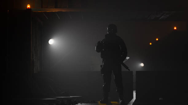 Armed soldier guarding a barricaded road at night