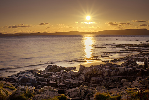 Sunset at rocky, sandy beach from Isle of Arran