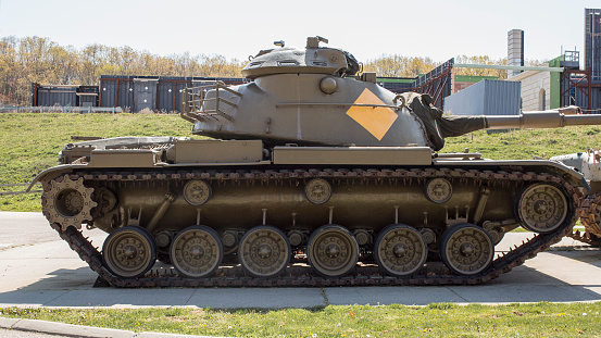 Main battle tank is a heavy armored fighting vehicle carrying guns and moving on a continuous articulated metal track.