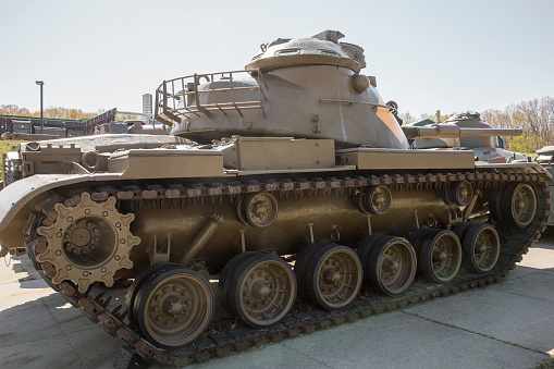 Main battle tank is a heavy armored fighting vehicle carrying guns and moving on a continuous articulated metal track.