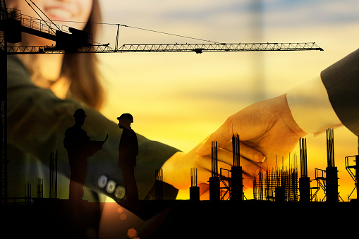 Double exposure Silhouette Businesswoman standing hand in hand to negotiate business success with an engineer working on construction site - Business industry etiquette, Congratulations, Negotiation.